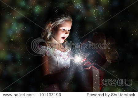 child opening a magic gift box with lights and shining around