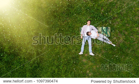 romantic couple of young people lying on grass in