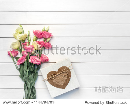 eustoma flowers and handmade gift box on white wooden background