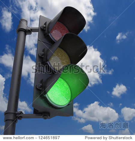 traffic light in a blue sky with only the green light on.
