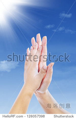 two hands clap together under blue sky