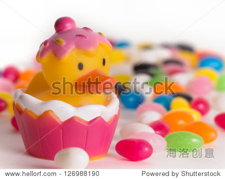 easter rubber ducks with colorful jelly beans out of focus in