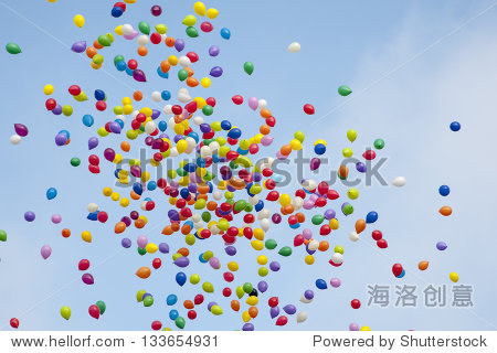 many colorful balloons flying in the air