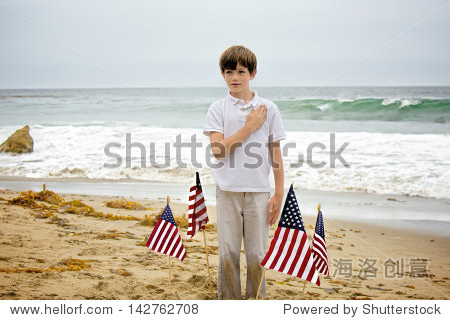 a young boy with sand all over his hands and pants plants four