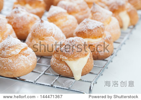 cream puffs filled vanilla custard and dusted with icing on a
