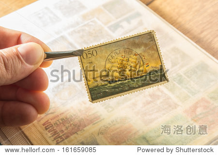 手拿着一个古老的南斯拉夫贴邮票-艺术,复古风