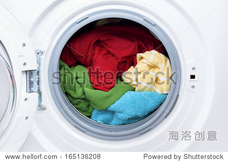 washing machine with dirty clothes inside studio