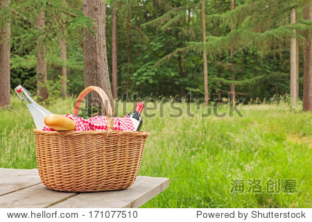 a whicker picnic basket full of food and drink on
