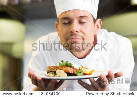 closeup of a male chef with eyes closed smelling food in the