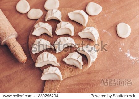 Cooking homemade dumplings or ravioli with meat on the table. Women's hands make dumplings. Traditional Russian dumplings. Culinary concept. Step-by-step instructions for cooking dumplings.
