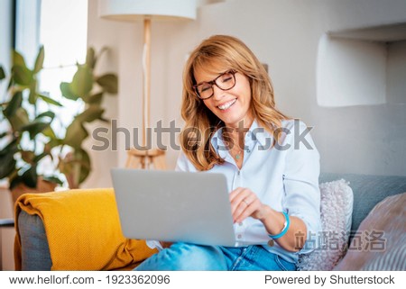 shot of a happy middle aged woman using her laptop on the sofa