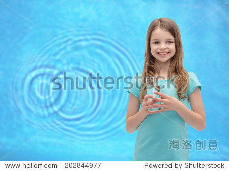 health and beauty concept - smiling little girl with glass of