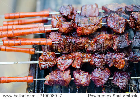 closeup on a bunch of ready-to-eat shishlik kebabs piled on the