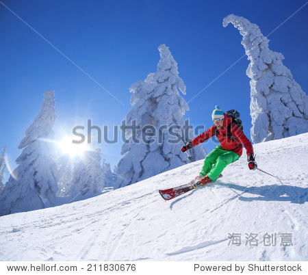 skier skiing downhill in high mountains against sunset