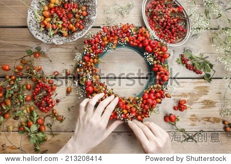 florist at work: woman making rose hip and hawthorn wreath