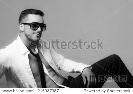收藏 sexy young male model wearing sunglasses sitting with