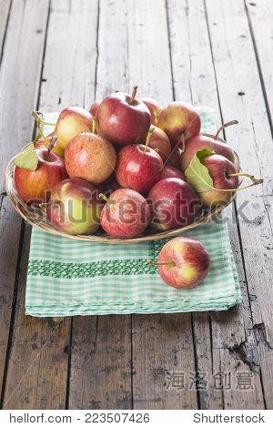 a basket with fresh red apples on a wooden table