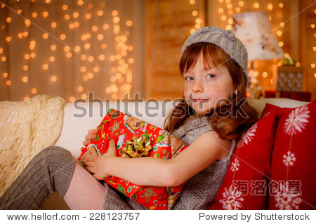 happy little girl at home holding a gift.