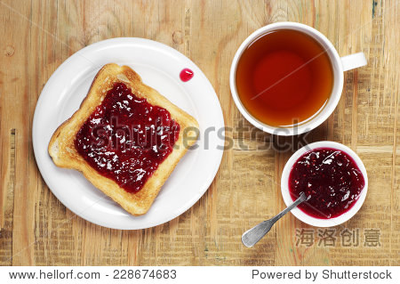 toast with jam and cup of tea on old wooden table. top view
