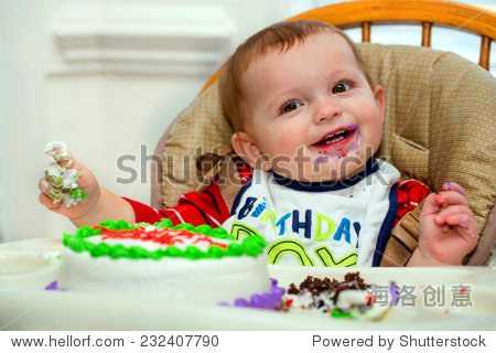 happy baby boy eating cake for his first birthday