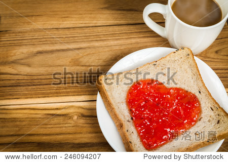 美味的面包片和草莓酱心形杯咖啡木制背景为情