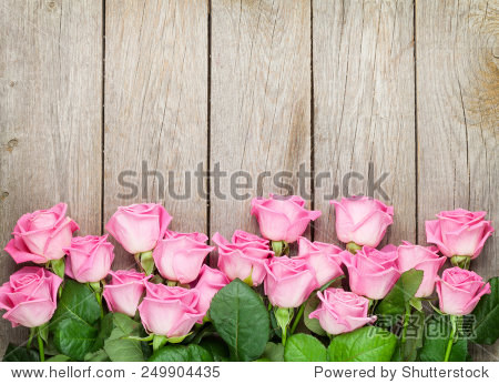 valentines day background with pink roses over wooden table.