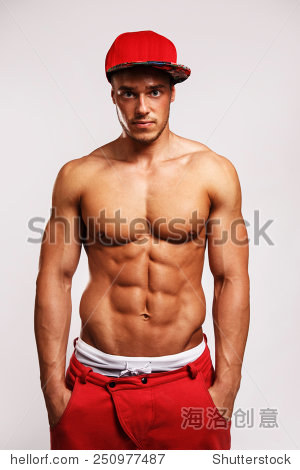 工作室肖像的肌肉男在红色运动裤和白色的条纹