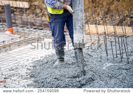 building construction worker pouring cement or concrete with