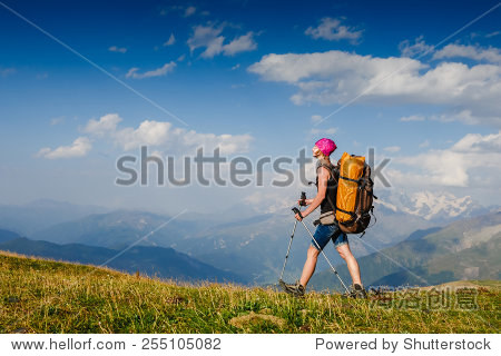 woman traveler with backpack hiking in mountains