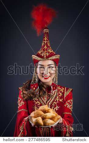 女人用红色国家哈萨克斯坦服装与baursak面包