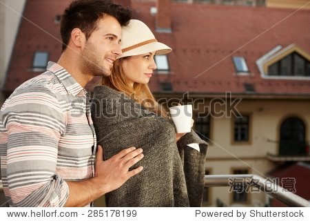 young loving couple embracing in balcony. side view.