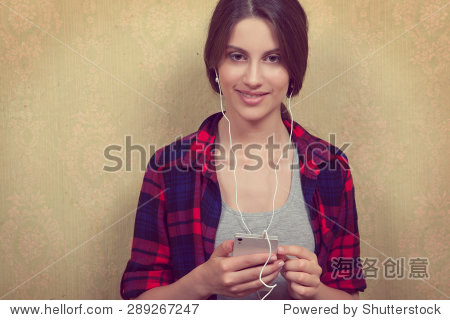 girl wearing headphones and listening to music in a red plaid