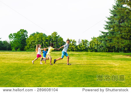 四个孩子在空地上玩耍。他们又跳又笑。-人物