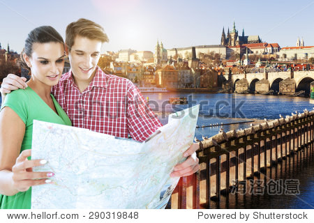 年轻的游客情侣看地图在布拉格查尔斯桥附近,