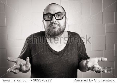 incredulous young bearded with glasses, with arms