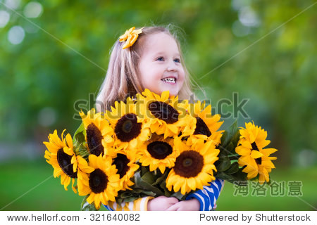 happy laughing little girl holding sunflower bouquet.