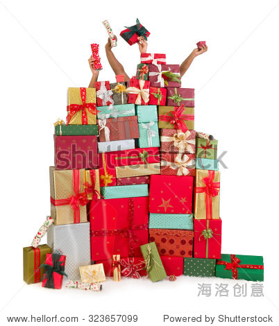 two people hiding behind a huge stack of christmas presents