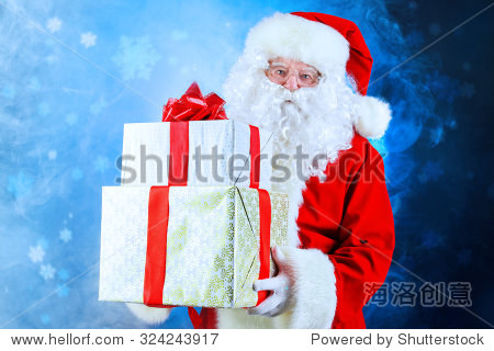 portrait of santa claus holding gift boxes. christmas time.