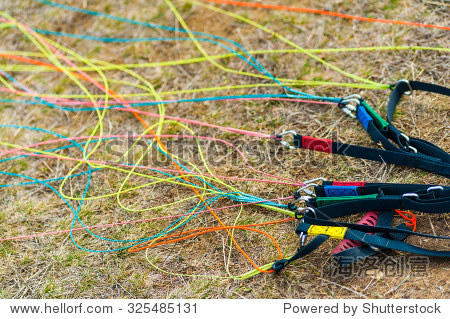 colorful strong kevlar paraglide cords tangled on the grassy