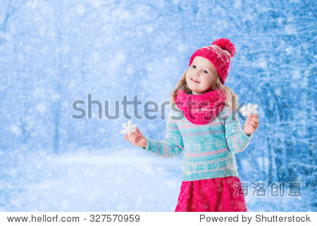 kids play outdoor in snowy forest. children catch snow flakes.