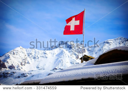 switzerland flag over swiss mountains in a winter
