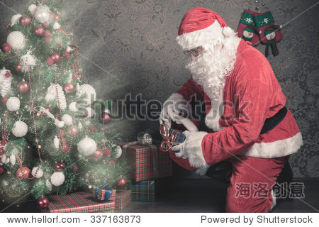 dady dressed in santa costume, putting gift box or present