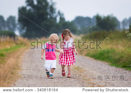 toddler kid and baby walk in the garden. summer shower.