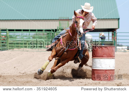 cowgirl racing her horse between poles during a rodeo.