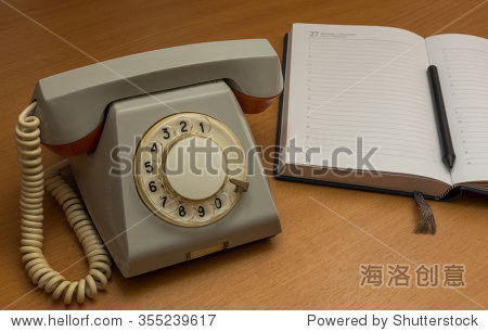 the photo depicts a landline phone with a notebook