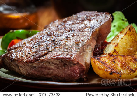 portions of grilled beef steak served with grilled potatoes and