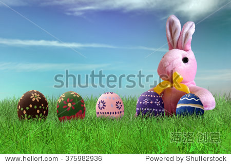 painted easter eggs and pink bunny on grass on sky background