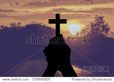 silhouette human hands holding a cross holy and prayed for