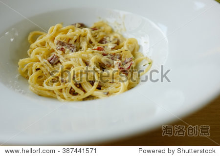 spagetti cabonara cream sauce and bacon on white