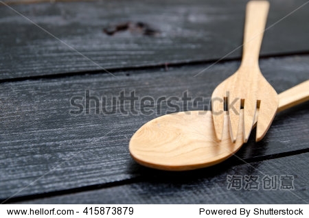 手工制作的木制厨具用叉子和勺子在黑色的木头
